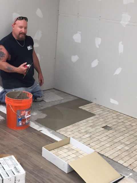 Tile installer, Calvin Pashley, is laying 2x2 mosaics for a shower floor. The is one of six 8 foot bathroom/shower displays in our new showroom. 